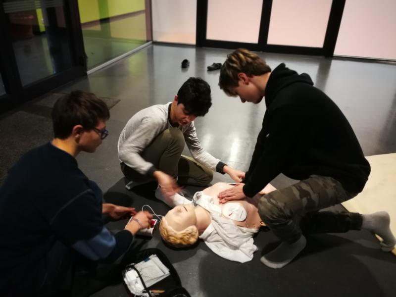 Drei Schüler mit Erste-Hilfe-Puppe